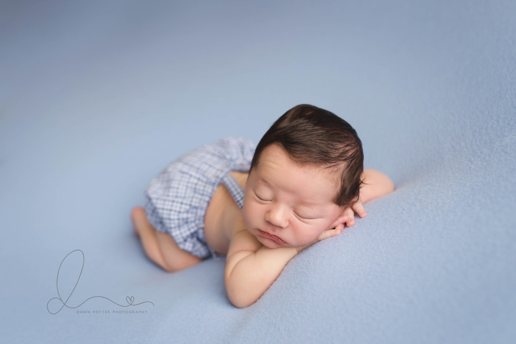 newborn baby boy head on hands