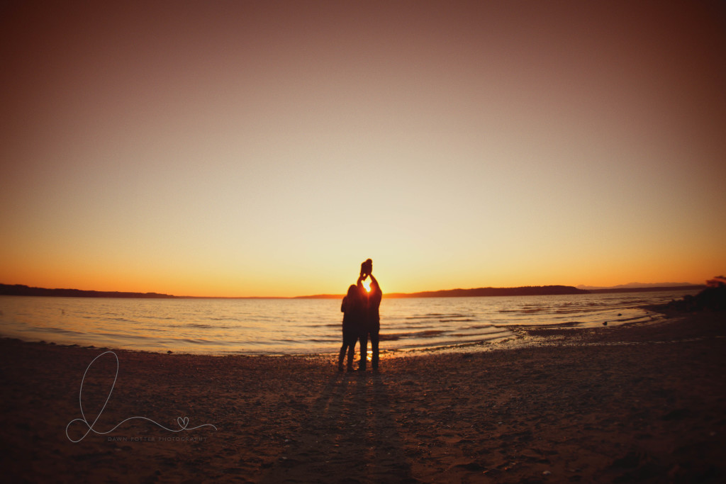 family silhouette on the beach at sunset